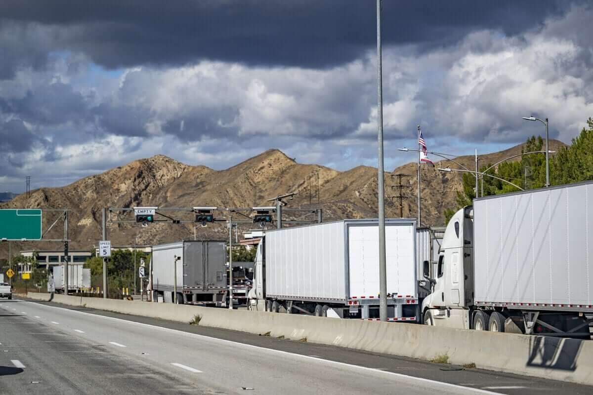 line of semis on a highway weighing station