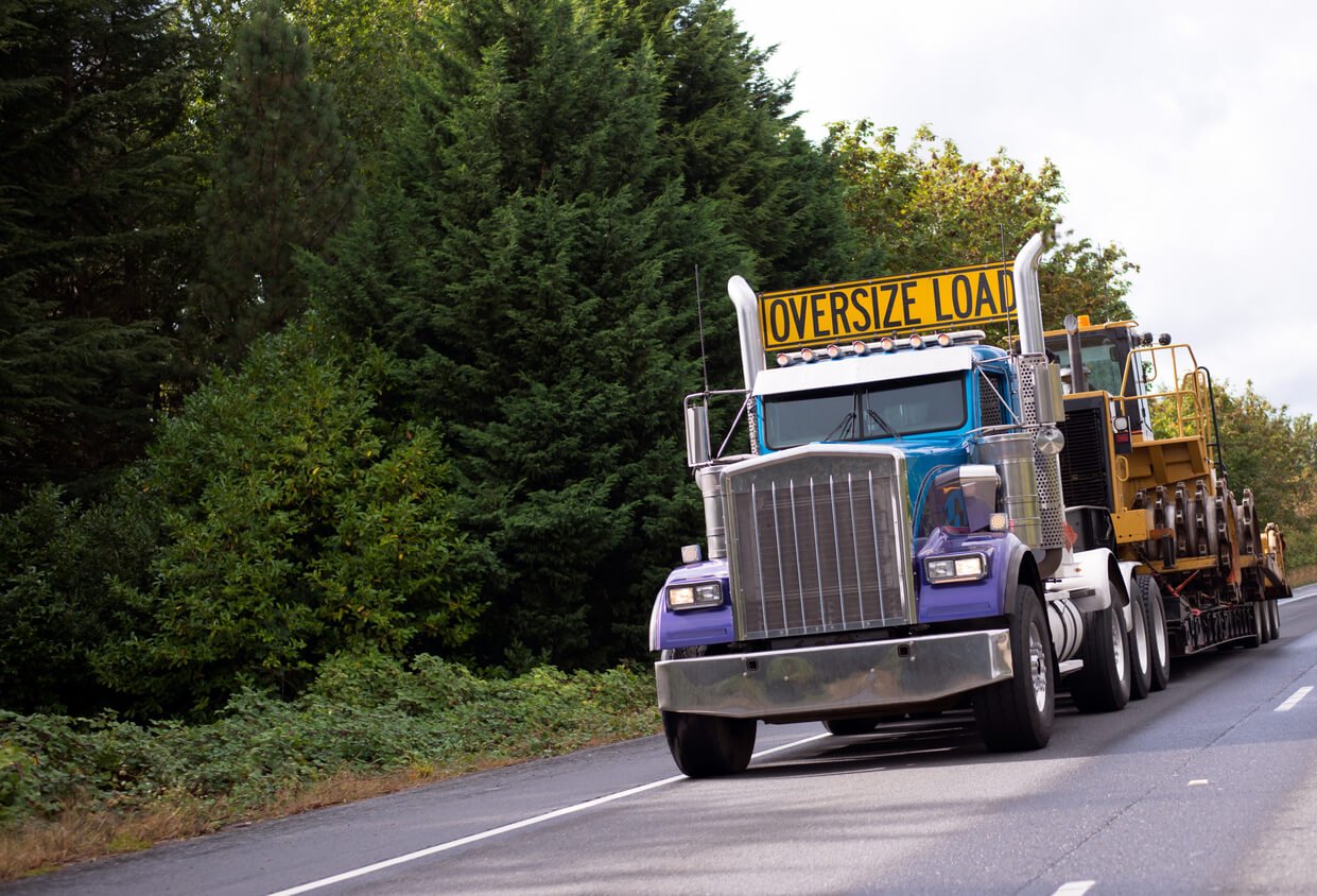 truck with oversize load sign driving down the hallway